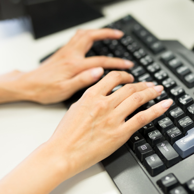 写真：パソコンのキーボードをたたく吉之内さんの手元