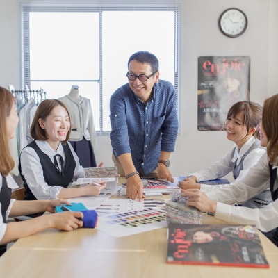 写真：社内でスタッフと打ち合わせをする田中さん