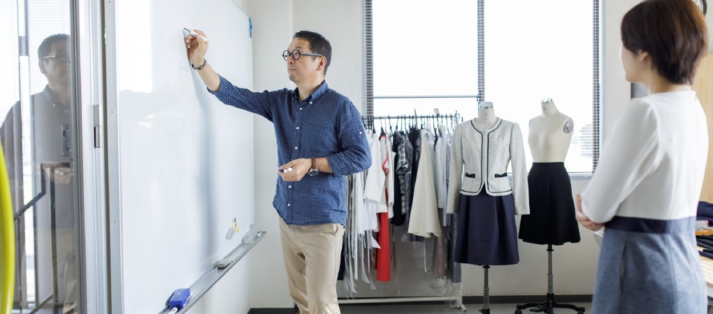 写真：ホワイトボードに書き込みをする田中さん