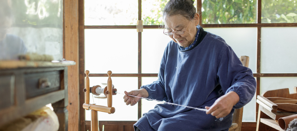 写真：糸をつむぐ岡さん